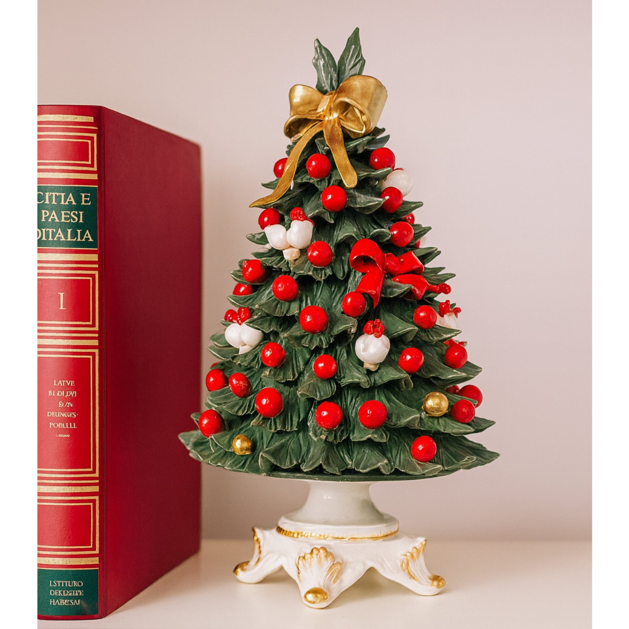 Albero natalizio in porcellana con decorazioni rosse e bianche.