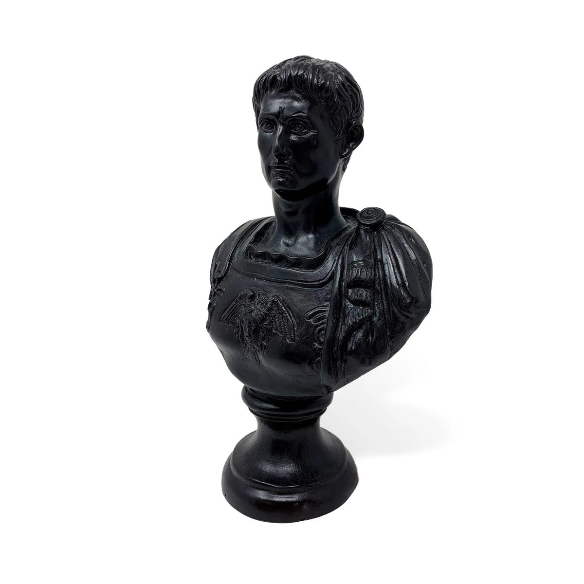 Busto in bronzo scuro dell’imperatore romano Augusto, fotografato di tre quarti con capelli scolpiti, corazza decorata e base rotonda.
