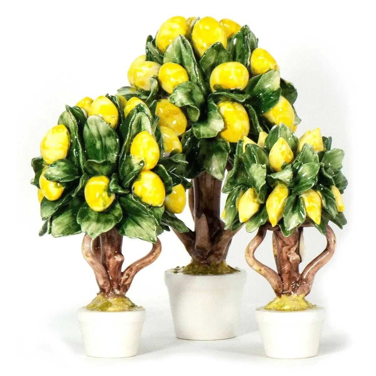 Tre alberi di limoni in porcellana di Capodimonte, disposti con il più alto al centro su fondo bianco.