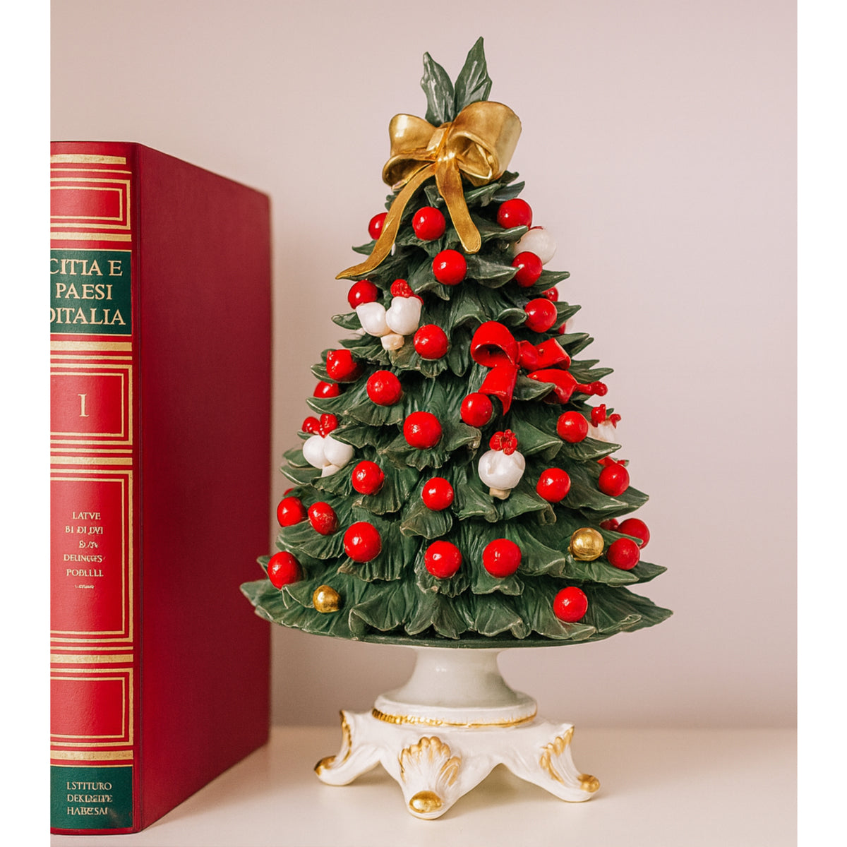 Albero natalizio in porcellana con decorazioni rosse e bianche.