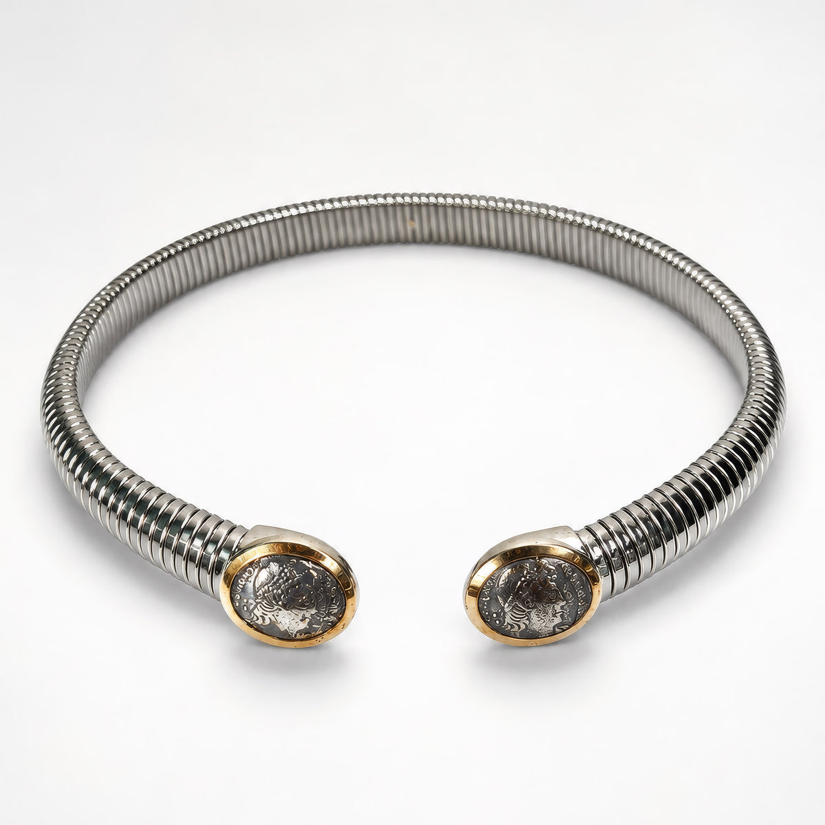 Collarino flessibile in acciaio con medaglioni in argento e bordi in oro su fondo bianco