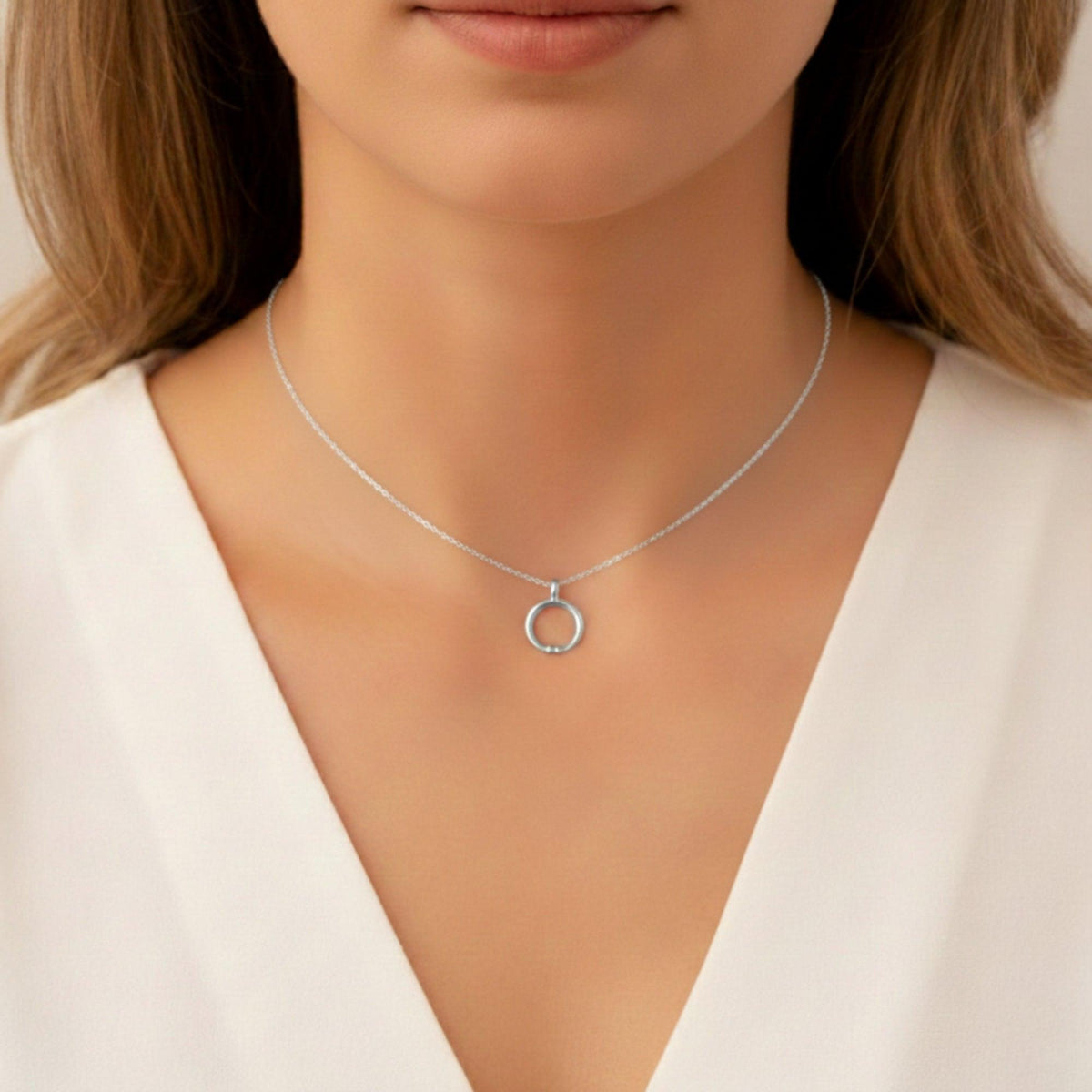 Pendente lunula liscia in argento con catenella, indossato con un capo bianco