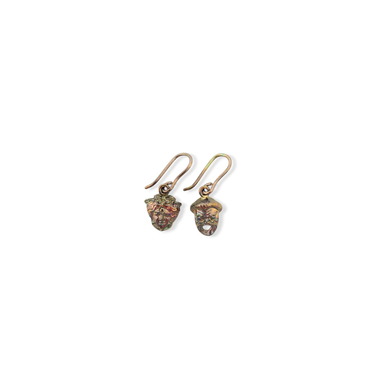 Coppia di orecchini in argento brunito con due diverse maschere teatrali greche e ganci, su fondo bianco