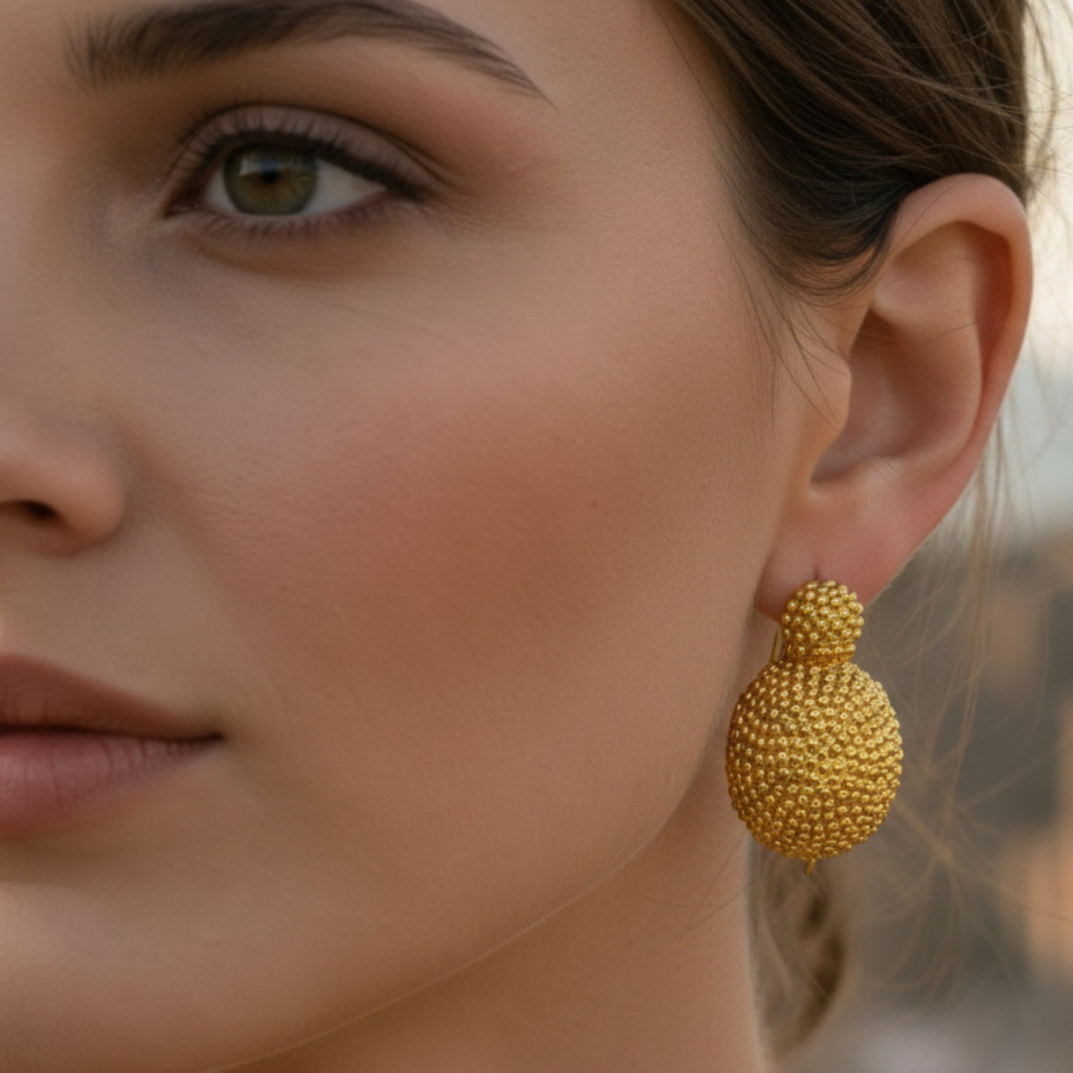 Orecchini a spicchio di sfera decorata in argento 925 e placcati in oro 18K indossati