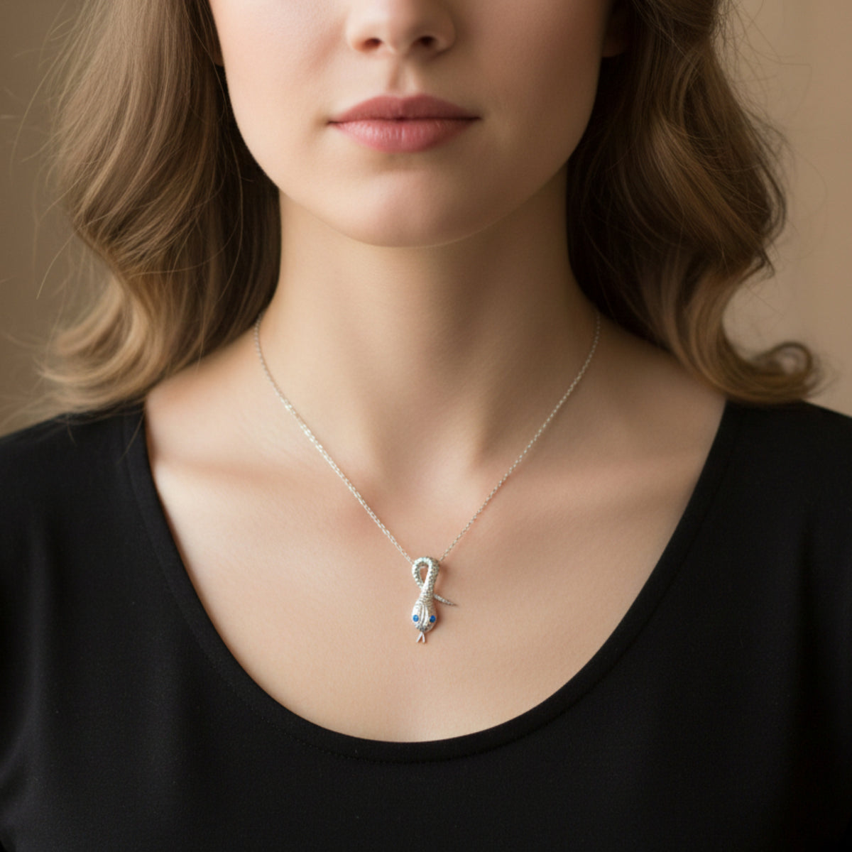 Pendente Serpentello in argento con occhi blu, indossato con una catenina