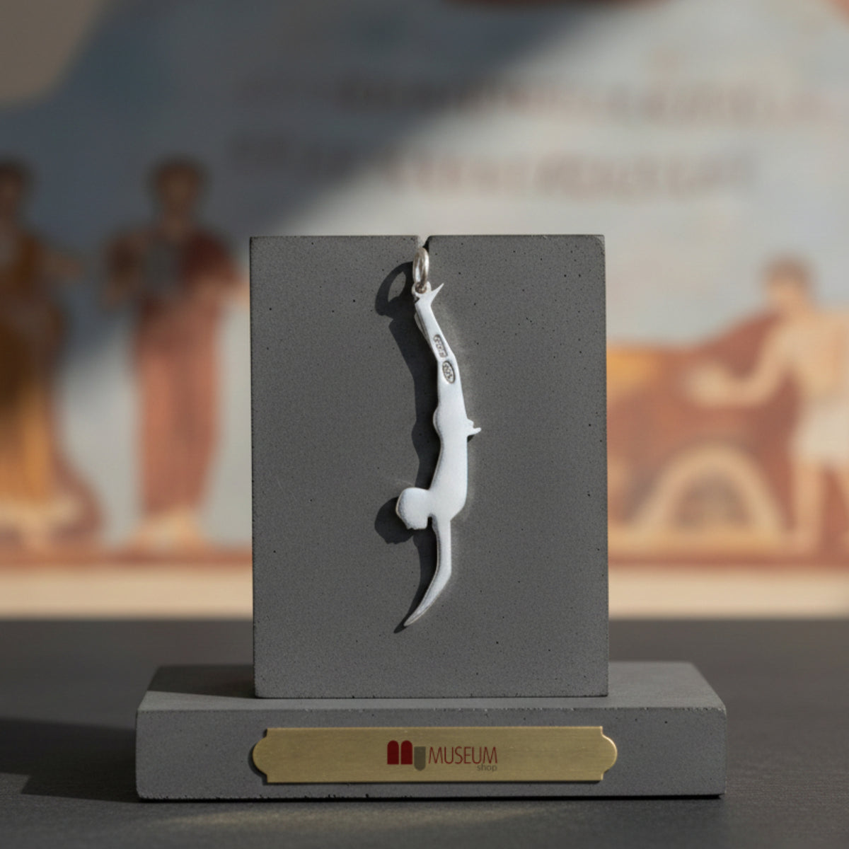 Pendente Tuffatore di Paestum grande in argento, su un espositore grigio