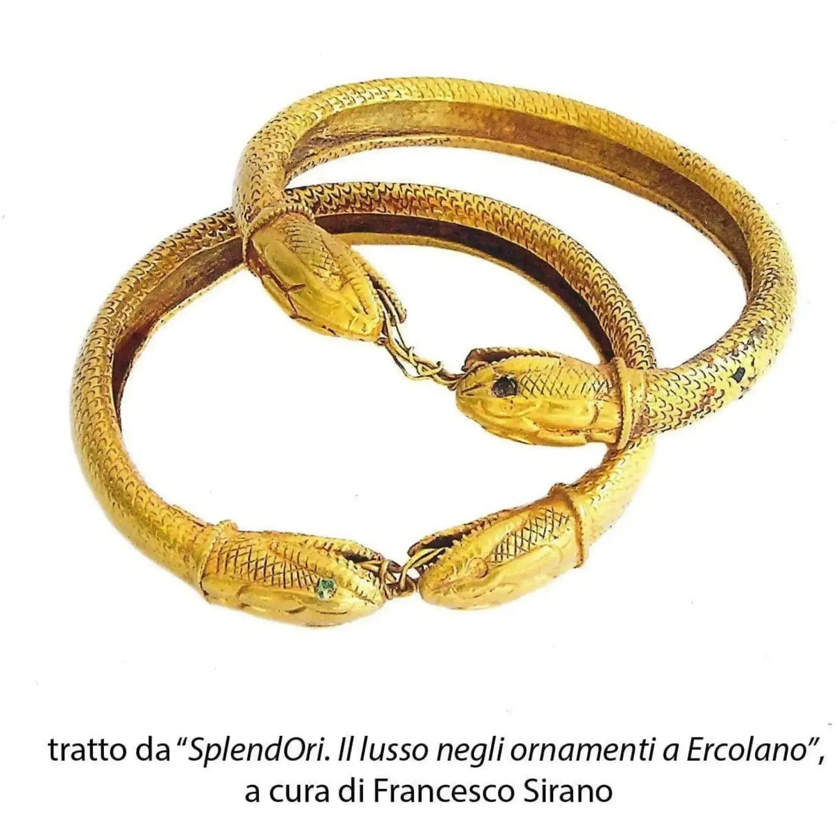Due armille antiche a serpente sovrapposte, con riferimento bibliografico in basso