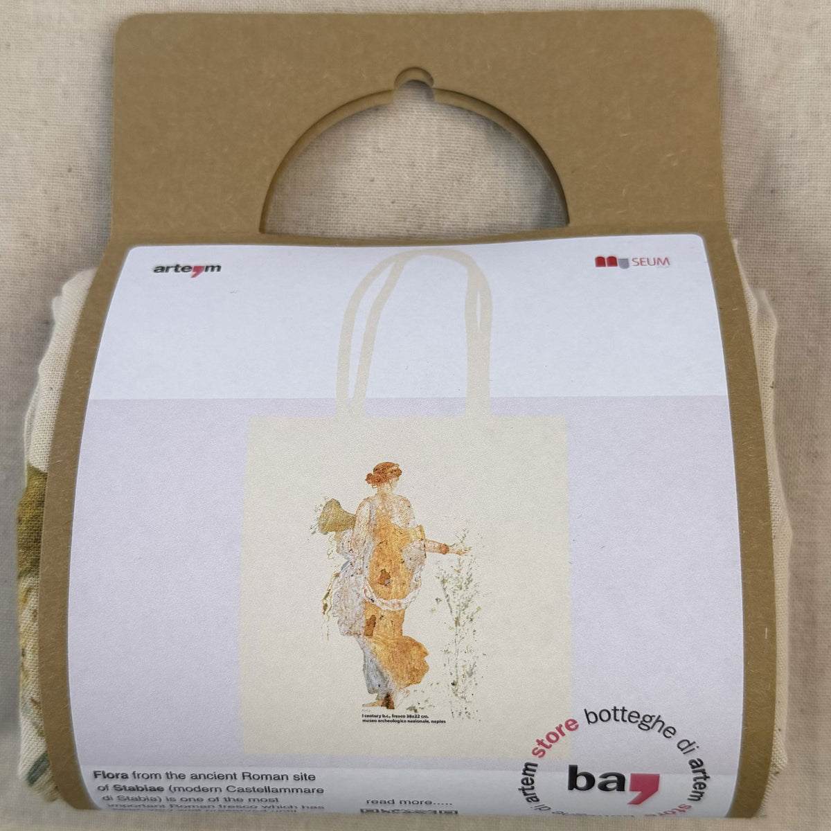 Shopper Flora ecru ripiegata nella confezione in cartoncino con illustrazione della borsa