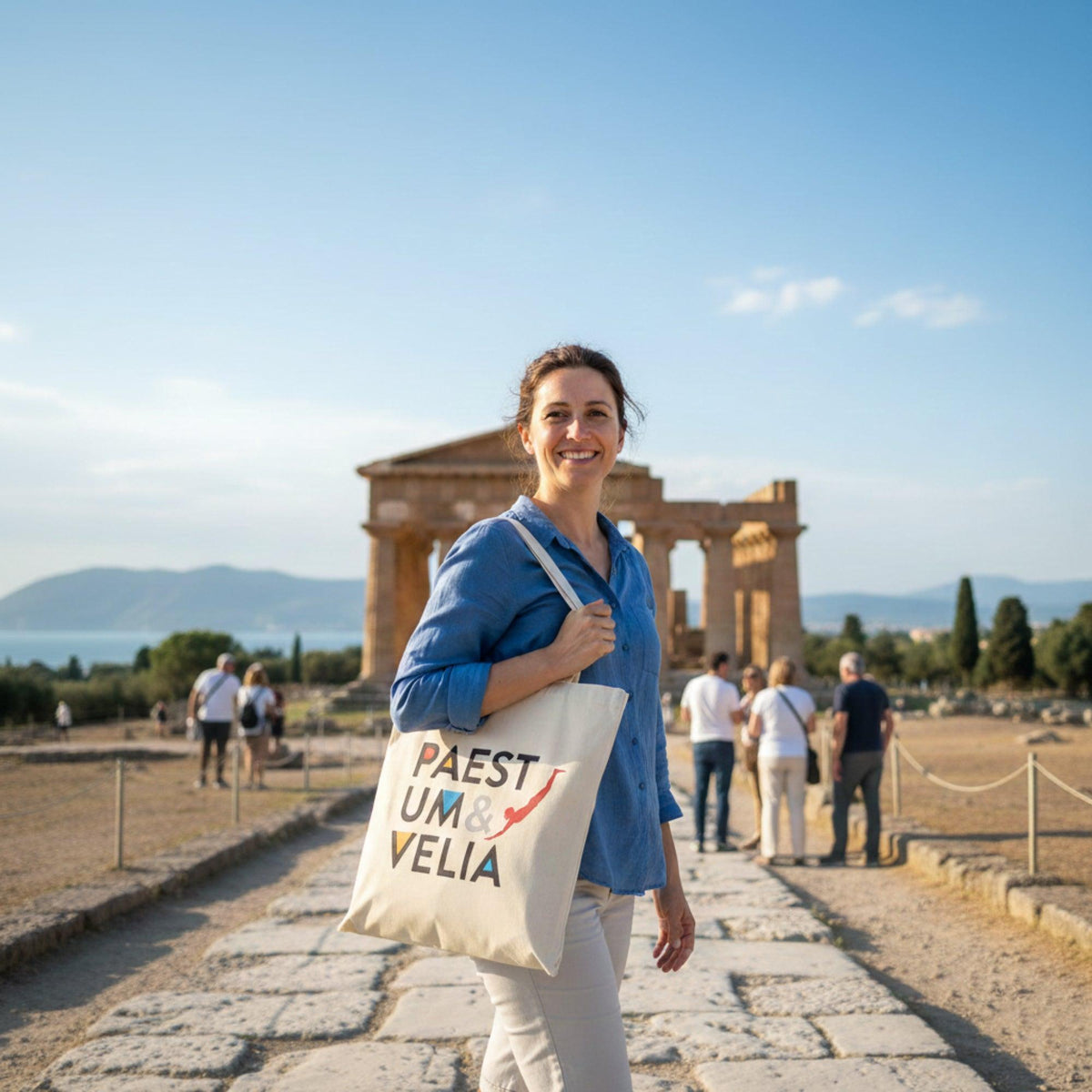 Shopper bianca in cotone Paestum & Velia, portata a spalla davanti a un tempio