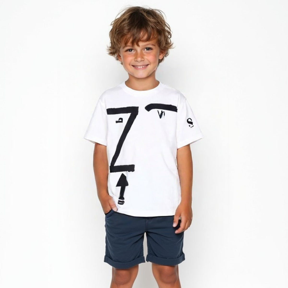 T-shirt bianca bambino Kounellis, con segni neri, indossata su fondo bianco