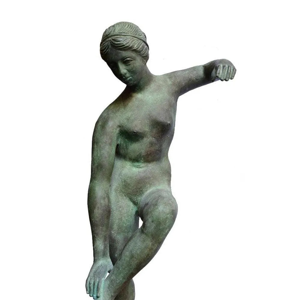 Dettaglio frontale della Venere al bagno in bronzo con patina verde, con la mano sulla gamba sollevata.