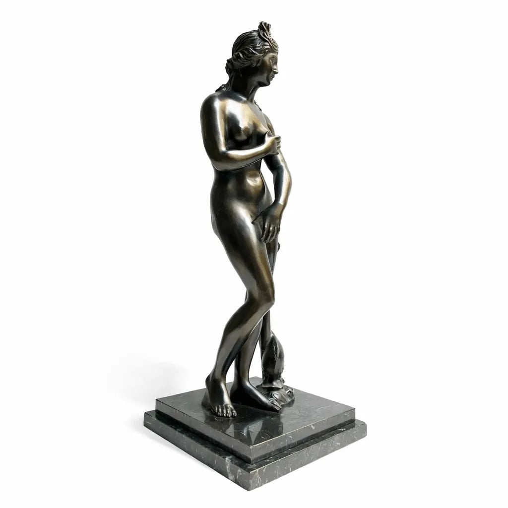 Venere dei Medici in bronzo scuro, vista laterale su base quadrata e fondo bianco.