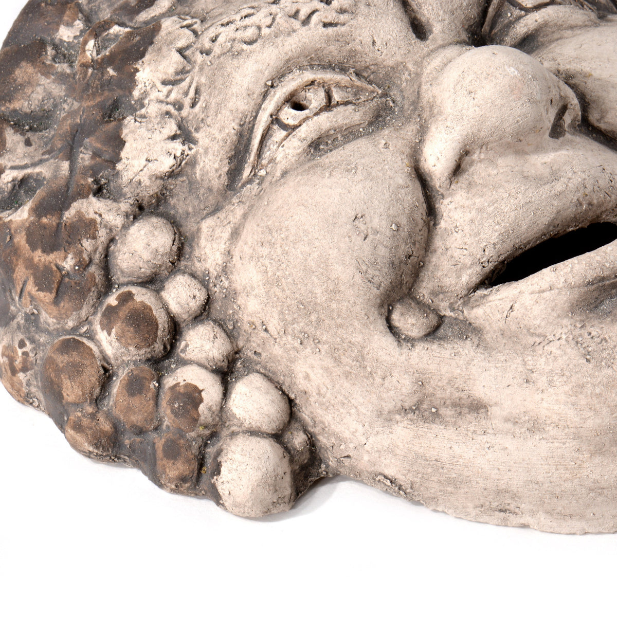 Dettaglio del volto sorridente e dei grappoli d’uva della maschera di Bacco in terracotta
