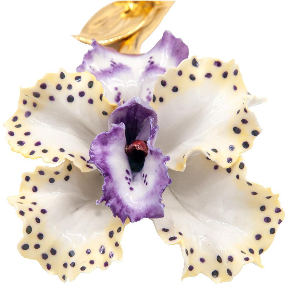 Dettaglio dei petali bianchi e viola punteggiati dell’orchidea in porcellana di Capodimonte.