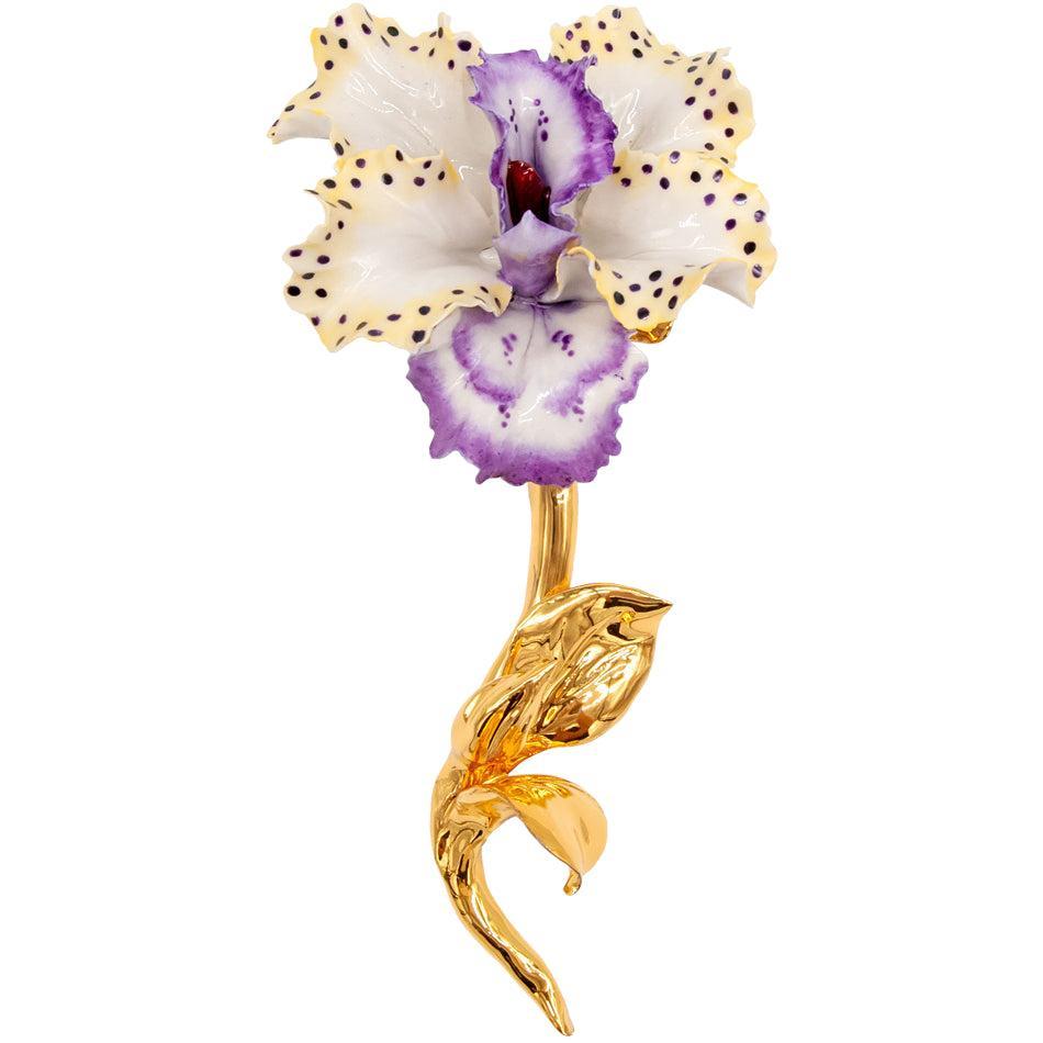 Orchidea in porcellana di Capodimonte con petali bianchi e viola punteggiati e gambo dorato, su fondo bianco.