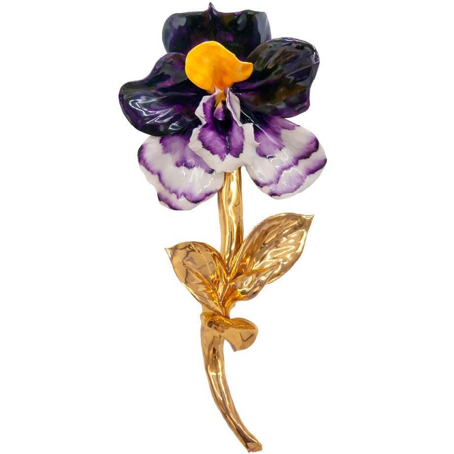 Orchidea viola e bianca in porcellana di Capodimonte, con centro giallo e gambo dorato su fondo bianco.