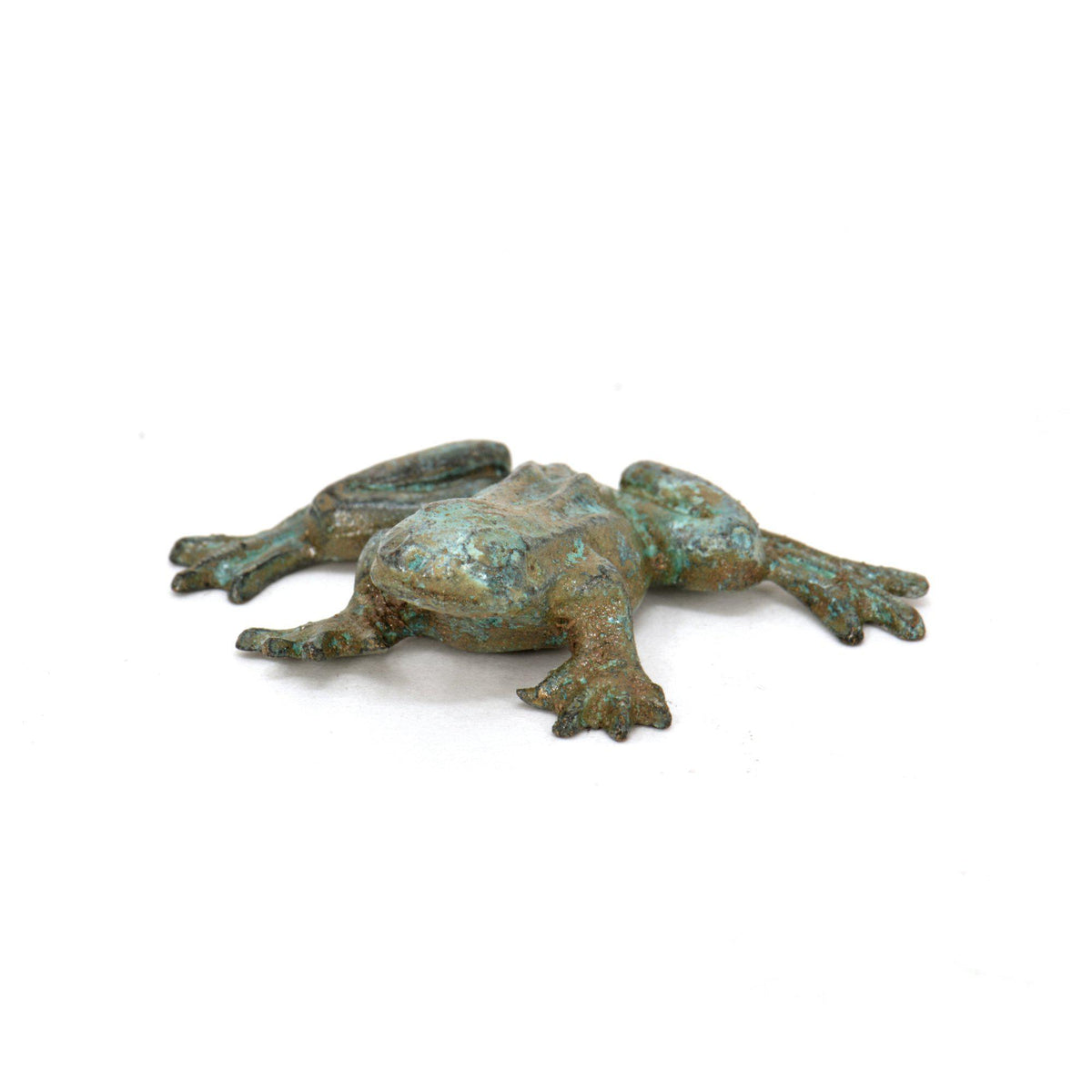 Pequeña escultura de rana de bronce con pátina verde-azulada, representada acostada sobre fondo blanco.