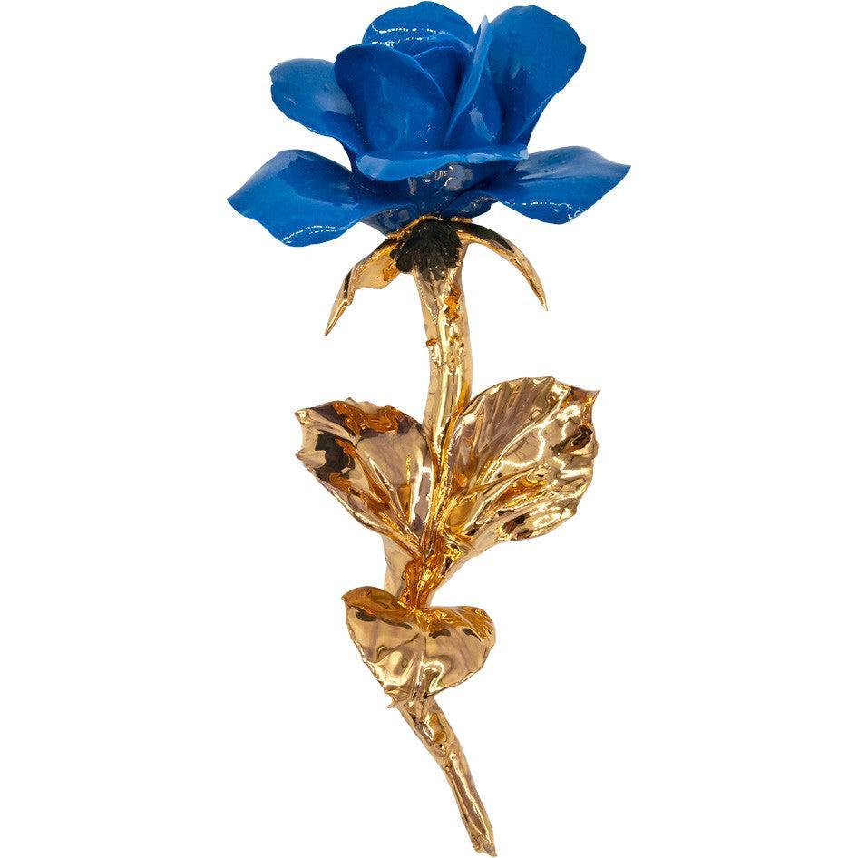 Rosa blu in porcellana di Capodimonte con gambo e foglie dorati, su fondo bianco.